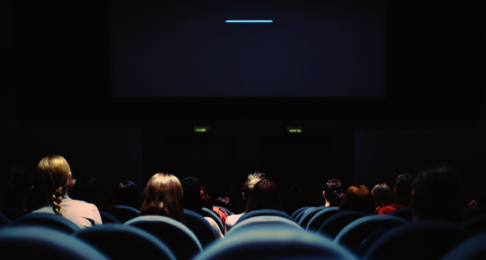 Inside a dark cinema screen as seen from the back