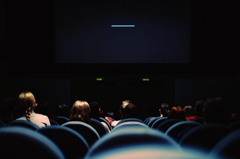 Inside a dark cinema screen as seen from the back
