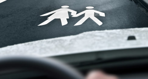 Mother & child sign on the road in front of a car