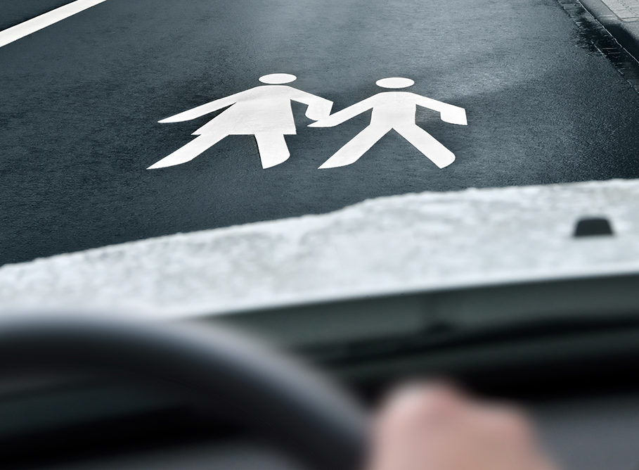 Mother & child sign on the road in front of a car
