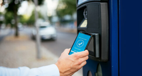 Millennial businessman using ticketing machine and paying contactless