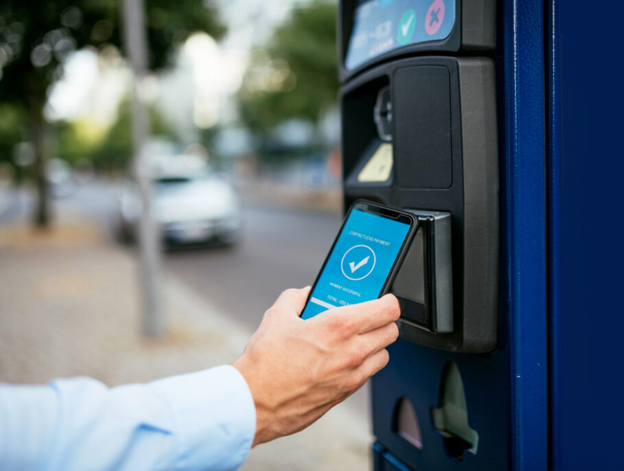 Millennial businessman using ticketing machine and paying contactless