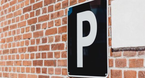 Black parking sign on a brick wall