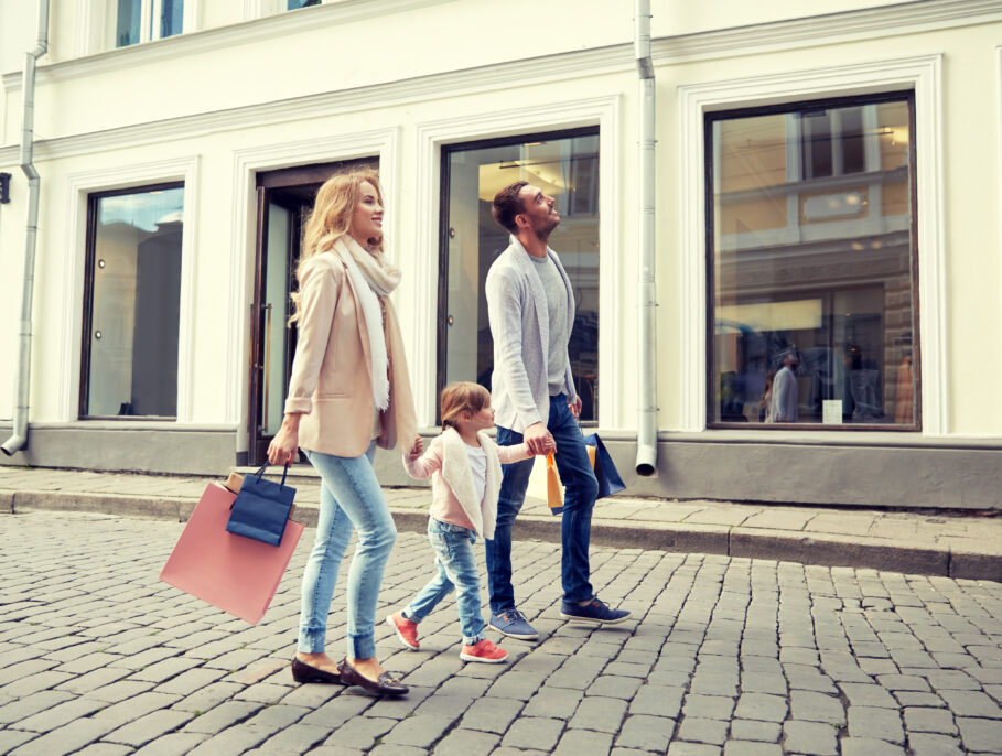 happy family with child and shopping bags in city
