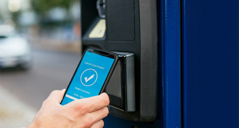 Electronic payments kiosk being used by a man with a mobile phone