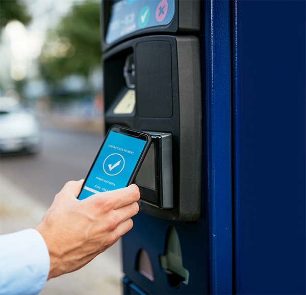 Electronic payments kiosk being used by a man with a mobile phone