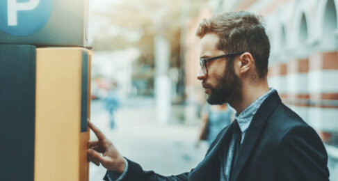 A man paying for parking using a kiosk