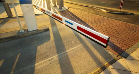 Close up of illuminated by warm sunset light car park barrier gate entrance