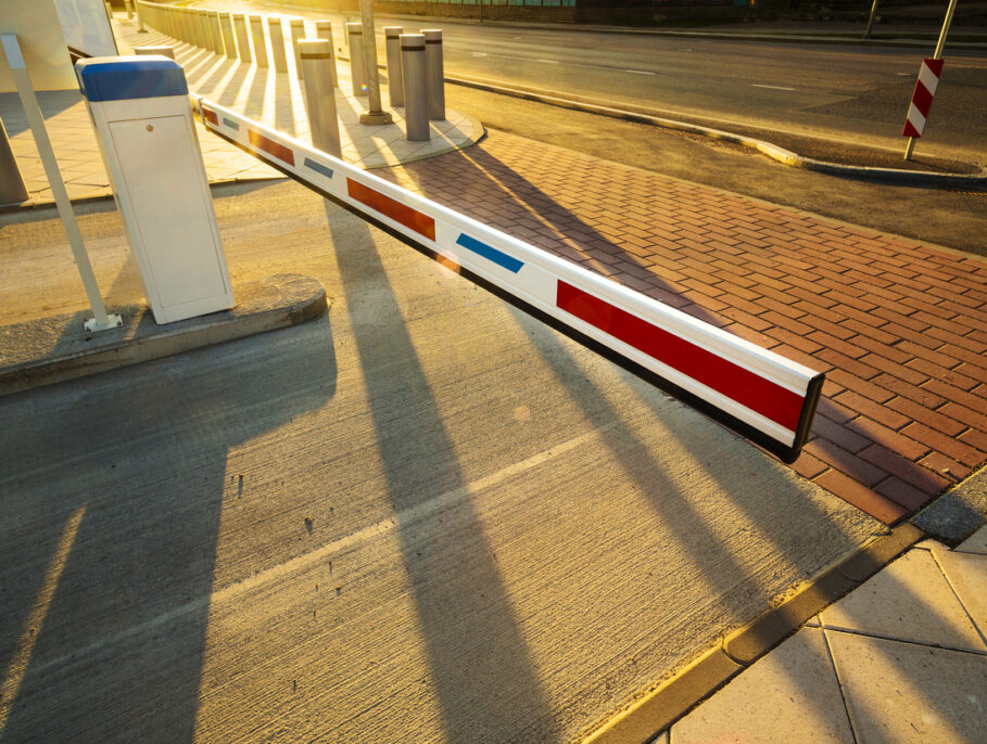 Close up of illuminated by warm sunset light car park barrier gate entrance