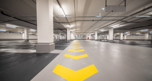An indoor car park with arrows marking the way