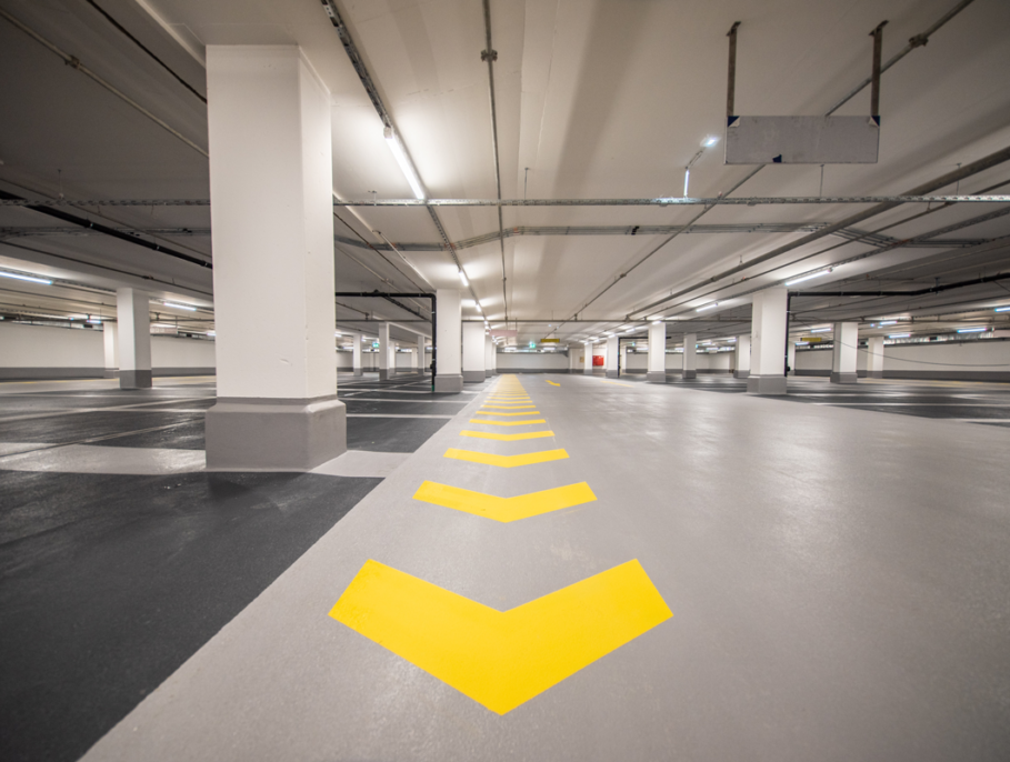 An indoor car park with arrows marking the way