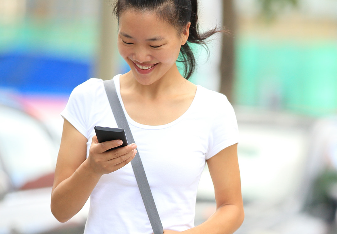 Woman checking her phone in a freedom leisure car park