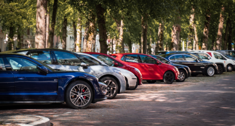Street parking filled with cars under tree cover