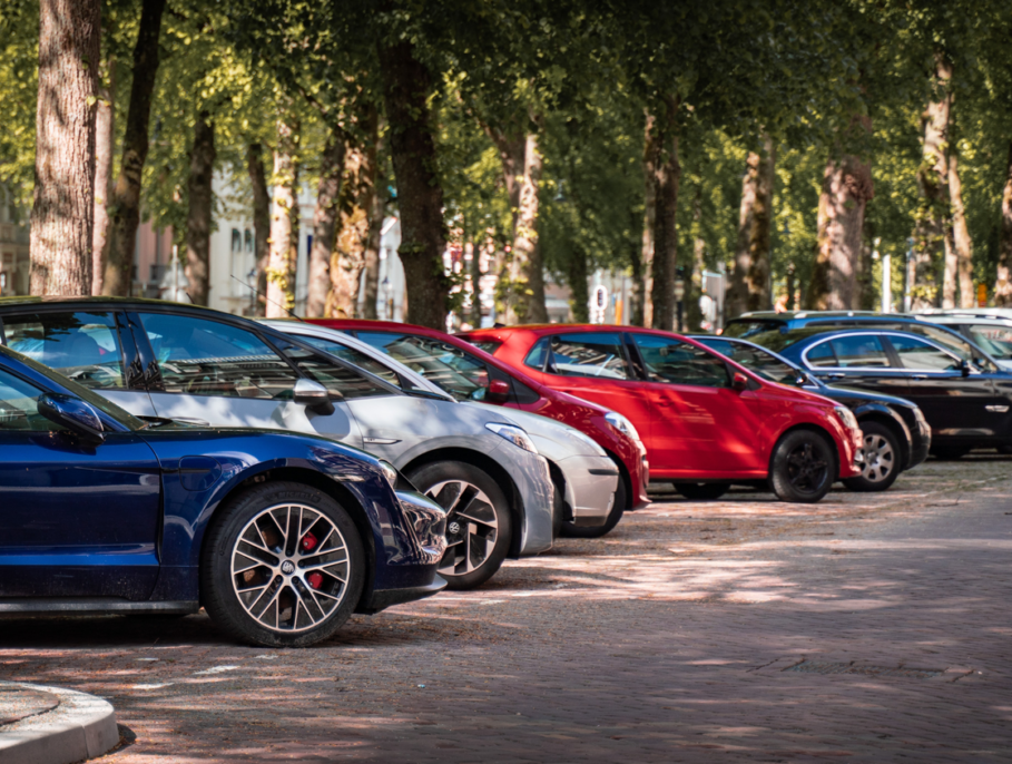 Street parking filled with cars under tree cover