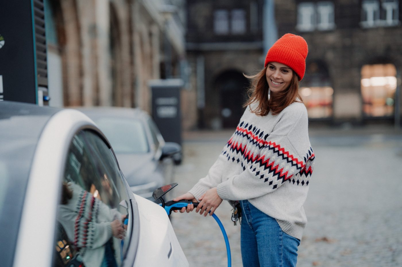 A woman charging her electric car at a charging point