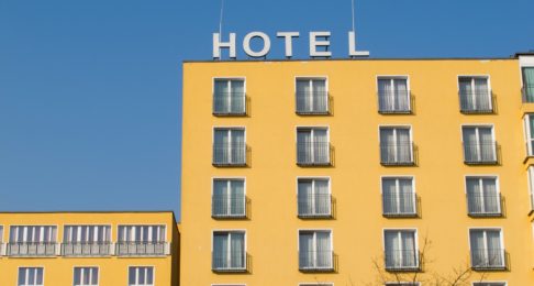 A yellow hotel with a sign on top