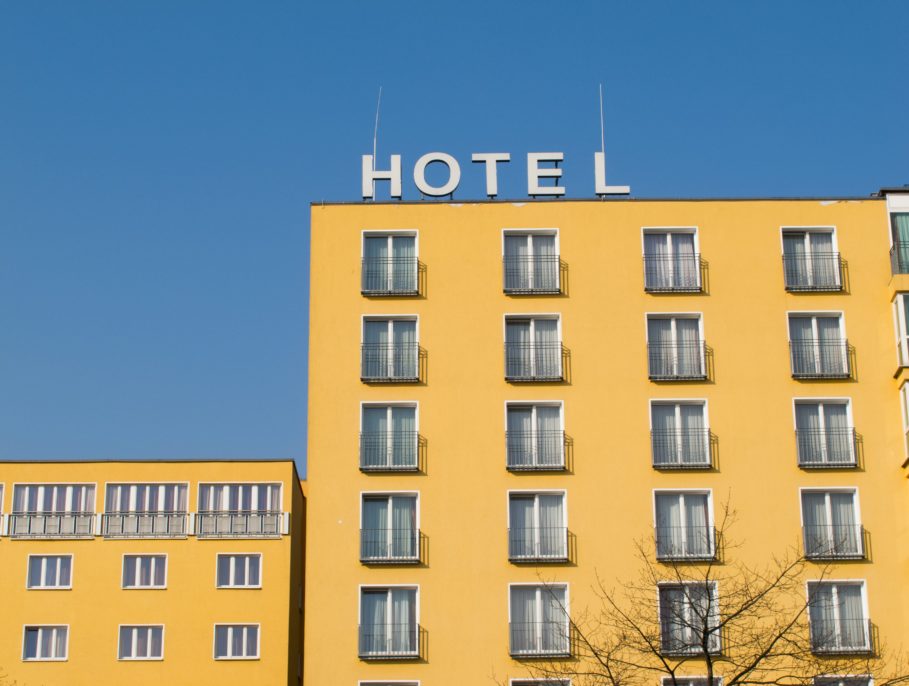 A yellow hotel with a sign on top