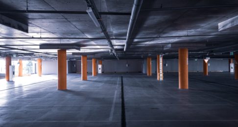 An empty underground car park ith yellow pillars