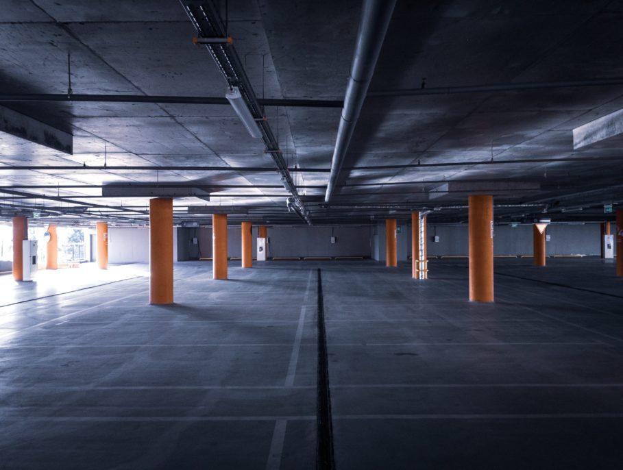 An empty underground car park ith yellow pillars