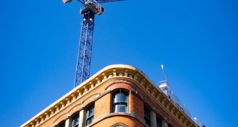 Crane towering over old historic building