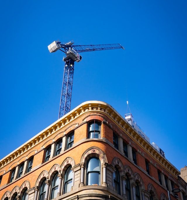 Crane towering over old historic building